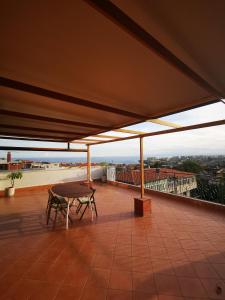 eine Terrasse mit einem Tisch auf dem Dach in der Unterkunft Monteforte Home - Ruggero in Catania