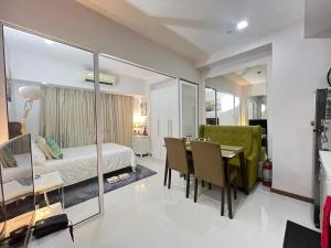 a bedroom with a bed and a table and chairs at Sakura apartment in Manila