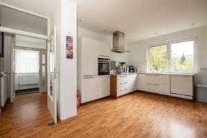 Villa Ennert في وينتربرغ: مطبخ مع خزائن بيضاء وأرضية من الخشب الصلب
