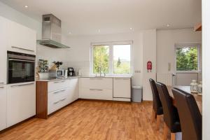 a kitchen with white cabinets and a table and chairs at Villa Ennert in Winterberg