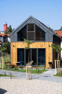 Krynica Family House في كرينيتا مورسكا: منزل على سقف أسود على شاطئ