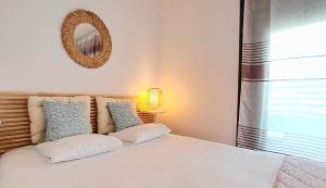 - une chambre avec un lit et un miroir mural dans l'établissement Noctua Apartamento Estepona centro, à Estepona