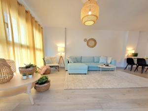 - un salon avec un canapé bleu et une table dans l'établissement Noctua Apartamento Estepona centro, à Estepona