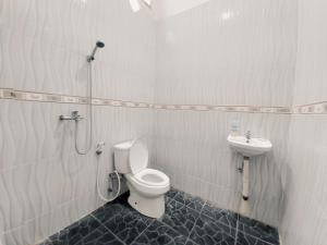 a bathroom with a toilet and a sink at Rumah Lavender near OPI Mall Jakabaring in Palembang