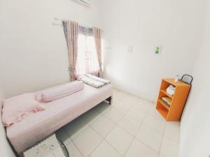 a small room with a bed and a window at Rumah Lavender near OPI Mall Jakabaring in Palembang