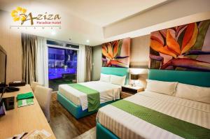 una camera d'albergo con due letti e un dipinto sul muro di Aziza Paradise Hotel a Città di Puerto Princesa