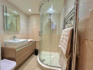 a bathroom with a glass shower and a sink at Brecon serviced apartments- Kian Perrott Properties in Brecon
