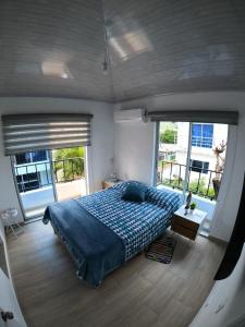 a bedroom with a large bed in a room with windows at Casa Vacacional en Nariño a 20 min de Girardot Cundinamarca in Nariño