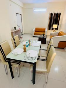 a dining table and chairs in a living room at HOTEL NAMAHA in Shamshabad
