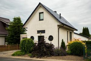 ein weißes Haus mit schwarzem Dach in der Unterkunft Ferienhaus Kottmann in Bremerhaven