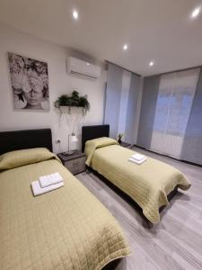 1 dormitorio con 2 camas con edredones amarillos en Monolocale Kamelia, 