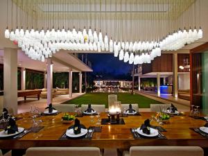a dining room with a table and a large chandelier at Villa Kalyani in Canggu