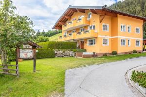 un gran edificio amarillo con un cartel delante en Appartement Nr 3 Alpenstern en Wagrain