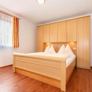 1 dormitorio con 1 cama grande con almohadas blancas en Appartement Nr 3 Alpenstern en Wagrain