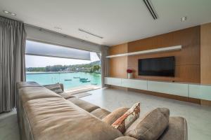 sala de estar con sofá grande y TV en 4-Storey, 3BR Seaview Villa Jayden, en Panwa Beach