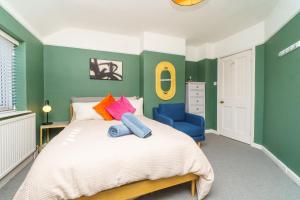 a green bedroom with a bed and a blue chair at 4BR House | WiFi | Parking in Bristol