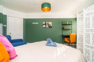 a bedroom with a white bed and green walls at 4BR House | WiFi | Parking in Bristol
