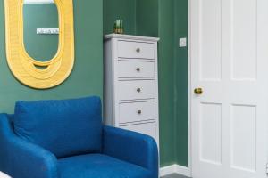 a blue chair in a room with a mirror at 4BR House | WiFi | Parking in Bristol