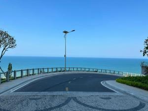 an empty road with a street light and the ocean at Apec Mandala Mui Ne Phan Thiet in Ấp Long Sơn