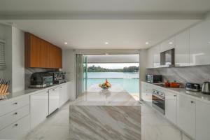 cocina con armarios blancos y encimera grande en 4-Storey, 3BR Seaview Villa Jayden, en Panwa Beach