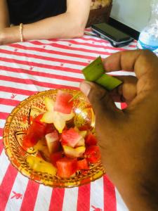 una persona sosteniendo una pieza de fruta en un plato en Laughing Jungle Unawatuna, en Galle