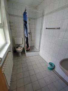 a bathroom with a shower and a toilet and a sink at Monteurzimmer - Waldbronn in Waldbronn