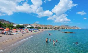 a group of people in the water at a beach at Villa Patitiri Traditional House with hot tub in Archangelos