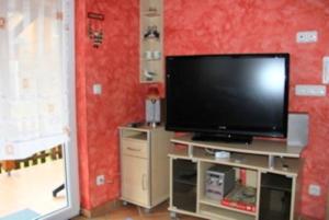 salon z telewizorem z płaskim ekranem w centrum rozrywki w obiekcie Ferienhaus Sonnenschein in Baabe w mieście Baabe