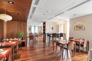 a restaurant with wooden floors and tables and chairs at Hotel Beau Rivage in Nice
