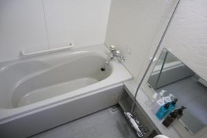 a white bath tub in a bathroom with a sink at STAY Moiwayama in Sapporo