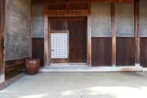 an empty room with a door and a pot at 古民家一棟貸 太田邸 in Yazu