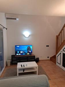 ein Wohnzimmer mit einem Sofa und einem Flachbild-TV in der Unterkunft NOUVEAU! Maison 2 pcs mezzanine dans résidence avec piscine in Tourrettes