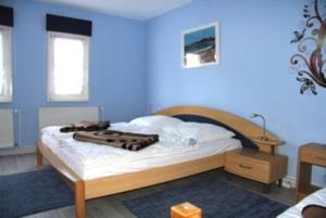 Schlafzimmer mit einem Bett mit blauer Wand in der Unterkunft Bungalow mit Terrasse in Glowe