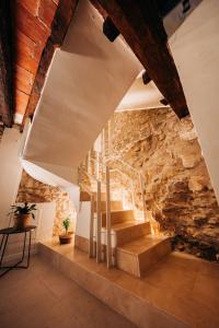 escalera en una habitación con pared de piedra en Casa Pelegrí, en Morella