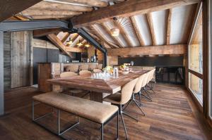 a dining room with a long wooden table and chairs at Chalet Eden Roc in Tignes