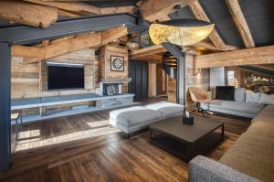 a living room with a couch and a tv at Chalet Eden Roc in Tignes