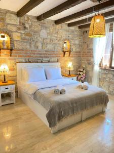 a bedroom with a large bed with towels on it at Ionia Liberty Stone in Foca
