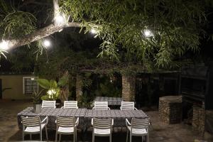 einen Tisch und Stühle in der Nacht mit Licht in der Unterkunft ENCHANTING SELF-CATERING VILLA with QUEEN BED AT BOKMAKIERIE VILLAS in Windhoek