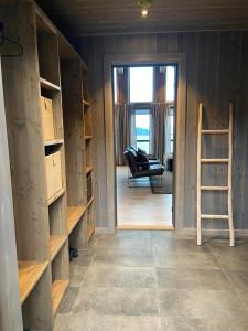 a room with shelves and a chair and a ladder at Hjortehytte in Åfarnes