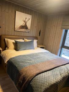 a bedroom with a bed with a deer picture on the wall at Hjortehytte in Åfarnes