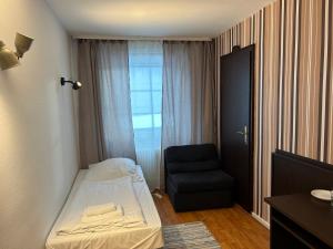 a small room with a bed and a chair at WestEnd#104 in Frankfurt