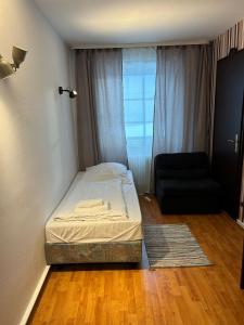 1 dormitorio pequeño con 1 cama y 1 silla en WestEnd#104, en Frankfurt