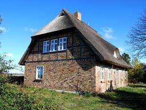 un antiguo edificio de ladrillo con techo de paja en Ferienwohnung Rügen in Putgarten, en Putgarten