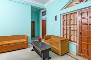 un soggiorno con 2 divani e un tavolo di OYO Archie Oasis a Bhubaneshwar