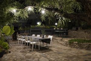 una mesa y sillas en un jardín por la noche en ALLURING SELF CATERING 2 BEDROOM VILLA at BOKMAKIERIE VILLAS en Windhoek