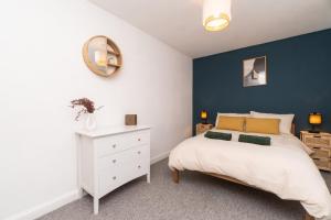 a bedroom with a white bed and a blue wall at WiFi | Parking | Near Major Attractions in Bath