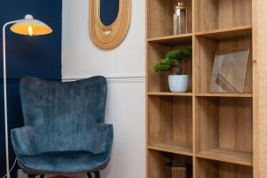 a blue chair sitting next to a book shelf at WiFi | Parking | Near Major Attractions in Bath