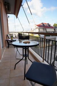 a balcony with two tables and a boat in the water at ΩκεανιςHouse 1 in Preveza