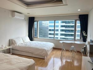 1 dormitorio con 1 cama, mesa y sillas en Hongik univ station Exit 1 en Seúl