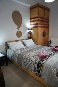 a bedroom with a bed with pink pillows on it at ΩκεανιςHouse 1 in Preveza